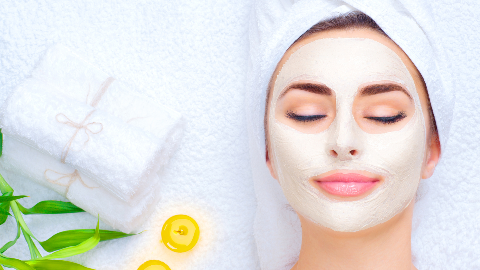 Lovely and Relaxed woman with pretty pink lipstick receiving a facial with greenery and lemon accents in the background 